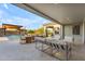 A covered patio has outdoor furniture and a dining area with a view of the pool and desert landscaping at 7130 E Navarro Way, Scottsdale, AZ 85266