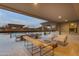 Outdoor patio with lounge seating, dining table, and retractable shades overlooks the desert landscape at 7130 E Navarro Way, Scottsdale, AZ 85266