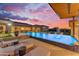 Beautiful backyard with a pool, sun loungers, and a covered outdoor kitchen area at 7130 E Navarro Way, Scottsdale, AZ 85266