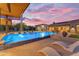 Stunning pool with fountains, lounge chairs, and an outdoor dining area at sunset at 7130 E Navarro Way, Scottsdale, AZ 85266