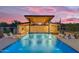 Beautiful pool featuring a covered structure, bar seating, lounge chairs, and blue LED lighting at 7130 E Navarro Way, Scottsdale, AZ 85266