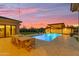 Inviting pool area with a covered patio, outdoor dining, and desert views at sunset at 7130 E Navarro Way, Scottsdale, AZ 85266