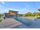 Spacious swimming pool with water features, an outdoor kitchen area, and manicured landscaping creating a serene retreat at 7130 E Navarro Way, Scottsdale, AZ 85266