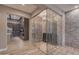 Gorgeous custom glass wine cellar adjacent to kitchen boasts stone wall and shelving at 7130 E Navarro Way, Scottsdale, AZ 85266