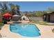 Backyard pool with an outdoor kitchen, umbrellas for shade, and mountain views in the distance at 7232 N 22 Nd St, Phoenix, AZ 85020