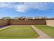 Backyard featuring a putting green, block wall, and paver walkway, creating a private outdoor space at 737 E Harwell Rd, Phoenix, AZ 85042