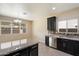 Well-lit kitchen with dark cabinetry, granite countertops, and stainless steel appliances at 737 E Harwell Rd, Phoenix, AZ 85042