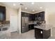 Bright kitchen featuring dark wood cabinets, stainless steel appliances, and a granite-topped island at 737 E Harwell Rd, Phoenix, AZ 85042