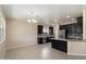 Stylish kitchen with granite countertops, dark cabinets, and stainless steel appliances, adjacent to living area at 737 E Harwell Rd, Phoenix, AZ 85042