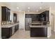 Modern kitchen with granite countertops, stainless steel appliances, and dark wood cabinets at 737 E Harwell Rd, Phoenix, AZ 85042