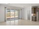 Bright living room features tile flooring and sliding glass doors to backyard with kitchen view at 7428 W Buckhorn Trl, Peoria, AZ 85383