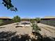 Gravel backyard featuring mature citrus trees, pergola seating area, and a garden box at 7551 W Darrel Rd, Laveen, AZ 85339