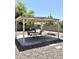 Backyard with gravel landscaping featuring a shaded pergola seating area with table and chairs at 7551 W Darrel Rd, Laveen, AZ 85339