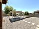Backyard with gravel landscaping featuring a shaded pergola seating area and mature trees at 7551 W Darrel Rd, Laveen, AZ 85339