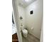 Half-bathroom featuring wood-look floors, stylish decor and a white toilet at 7551 W Darrel Rd, Laveen, AZ 85339