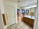 Bathroom with a double sink vanity, wood-look floors, and horse-themed shower curtain at 7551 W Darrel Rd, Laveen, AZ 85339