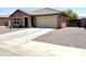 Attractive single-story house featuring a spacious driveway, desert landscaping, and a convenient two-car garage at 7551 W Darrel Rd, Laveen, AZ 85339