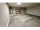 Garage featuring concrete flooring, neutral walls, shelving, an installed water heater, and garage door at 7551 W Darrel Rd, Laveen, AZ 85339