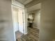 Hallway view with wood flooring and view into a room with styled decorations and mirror at 7551 W Darrel Rd, Laveen, AZ 85339