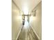 Long hallway with wood flooring and neutral paint leading to the bright entrance of the home at 7551 W Darrel Rd, Laveen, AZ 85339