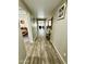 Long hallway with lovely wood flooring and neutral paint leading to a well-lit living space and bedroom at 7551 W Darrel Rd, Laveen, AZ 85339