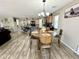 Open kitchen and dining area features wood floors, center island, and modern light fixture at 7551 W Darrel Rd, Laveen, AZ 85339