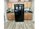 Bright kitchen with wood cabinets and black refrigerator with water dispenser at 7551 W Darrel Rd, Laveen, AZ 85339