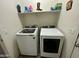 Bright laundry area with modern white washer and dryer with overhead storage shelf at 7551 W Darrel Rd, Laveen, AZ 85339
