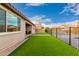 Fenced backyard with green turf and a covered patio at 7829 W Warner St, Phoenix, AZ 85043