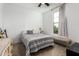 Bright bedroom featuring a ceiling fan, large window, bench, and stylish patterned bedding at 7829 W Warner St, Phoenix, AZ 85043