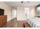 Light and airy bedroom showcases neutral walls and trim and modern wood-look flooring at 7829 W Warner St, Phoenix, AZ 85043