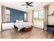 A stylish bedroom with a large window, ceiling fan and a decorative accent wall at 7829 W Warner St, Phoenix, AZ 85043
