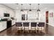 Bright, open kitchen with white cabinets, stainless steel appliances, and a large granite island with seating for four at 7829 W Warner St, Phoenix, AZ 85043