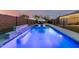 Sparkling blue pool featuring relaxing lounge chairs, rock waterfall and secure fencing, perfect for leisure at 7829 W Warner St, Phoenix, AZ 85043