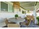 Back porch with a stone table and woven chairs and hanging light fixtures at 8021 N 16Th Dr, Phoenix, AZ 85021