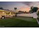 Backyard with putting green, artificial turf, and covered outdoor living area with decorative string lights at 8021 N 16Th Dr, Phoenix, AZ 85021
