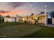 Large backyard featuring a putting green, artificial turf, and inviting patio area with ambient string lights at 8021 N 16Th Dr, Phoenix, AZ 85021