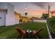 Serene backyard features artificial turf, lounge chairs, and ambient string lights for relaxing evenings at 8021 N 16Th Dr, Phoenix, AZ 85021