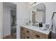 Bathroom vanity area with wooden cabinets, modern faucet, and view to bedroom at 8021 N 16Th Dr, Phoenix, AZ 85021