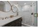 Bathroom featuring double sinks, elegant lighting, and a spacious, glass-enclosed shower at 8021 N 16Th Dr, Phoenix, AZ 85021