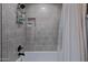 Bathroom shower with gray subway tile surround, black fixtures, and recessed niche for toiletries at 8021 N 16Th Dr, Phoenix, AZ 85021