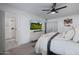 Bright bedroom featuring a modern TV, ceiling fan, and ensuite bathroom with glass shower at 8021 N 16Th Dr, Phoenix, AZ 85021