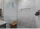 Close-up of a modern glass shower with bench, niche, and stylish tile work at 8021 N 16Th Dr, Phoenix, AZ 85021