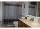 Modest bathroom featuring a single sink vanity and a shower with striped curtain at 8802 W Cinnabar Ave, Peoria, AZ 85345