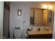 Simple bathroom with a single sink vanity, mirror, and a toilet with tissue and supplies at 8802 W Cinnabar Ave, Peoria, AZ 85345