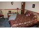 Cozy bedroom with warm-toned bedding, bedside table, decorative wallpaper, and blue carpeting at 8802 W Cinnabar Ave, Peoria, AZ 85345