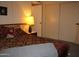 Bedroom with patterned bedding, bedside table with lamp, and a built-in closet providing ample storage at 8802 W Cinnabar Ave, Peoria, AZ 85345