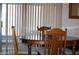 A dining area featuring wood furniture and vertical blinds that allow for natural light at 8802 W Cinnabar Ave, Peoria, AZ 85345