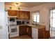 Classic kitchen featuring wood cabinets, white appliances, and a window overlooking the outside at 8802 W Cinnabar Ave, Peoria, AZ 85345