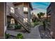 A well-maintained condo exterior features classic desert landscaping, with walkways and exterior stairs visible at sunset at 930 N Mesa Dr # 1079, Mesa, AZ 85201